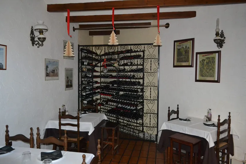 Interior de La Herradura con mesas y bodega